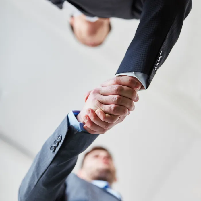 Dos personas estrechándose las manos mostrando un acuerdo