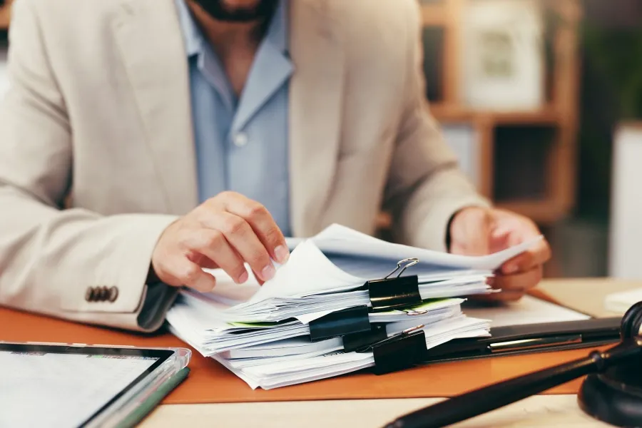 abogado de derecho administrativo sentado en una mesa organizando los papeles de un caso